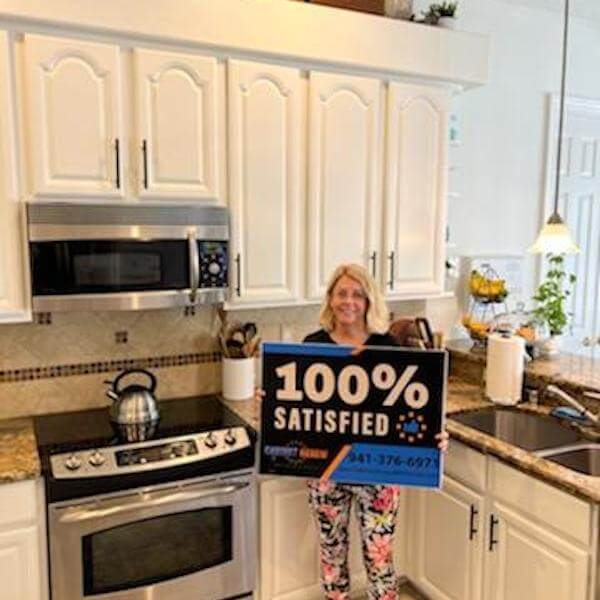 Customer holding a 100% Satisfied sign after a kitchen project